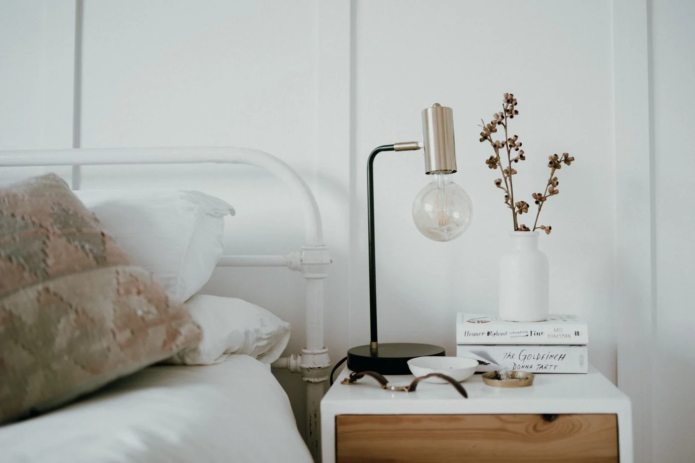 Bedside lamp on a small table beside a bed