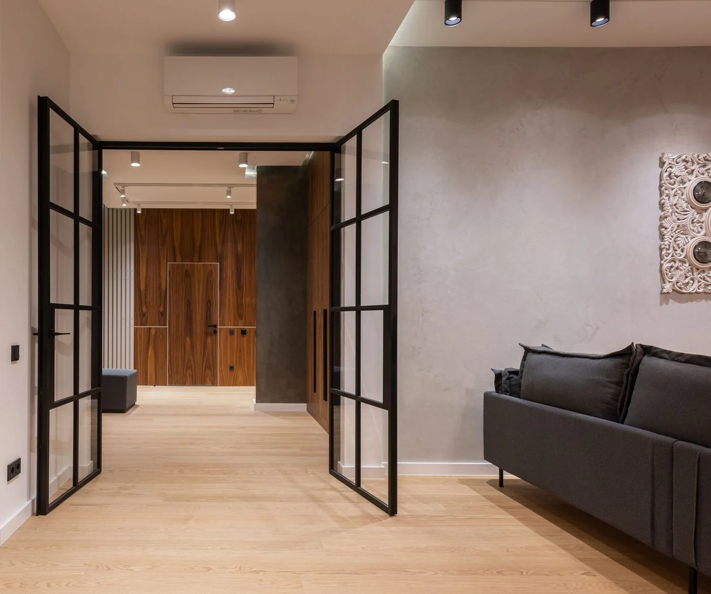 Sofa beside open doors and a hallway
