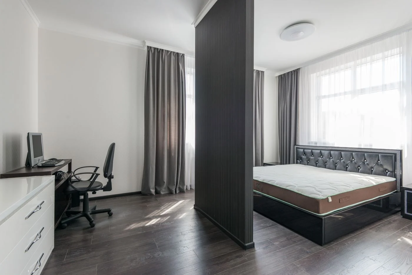 Sleeping area beside a desk in a shared room