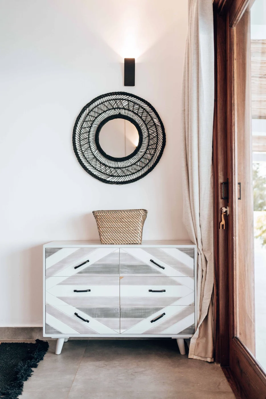 Wooden chest of drawers against a white wall