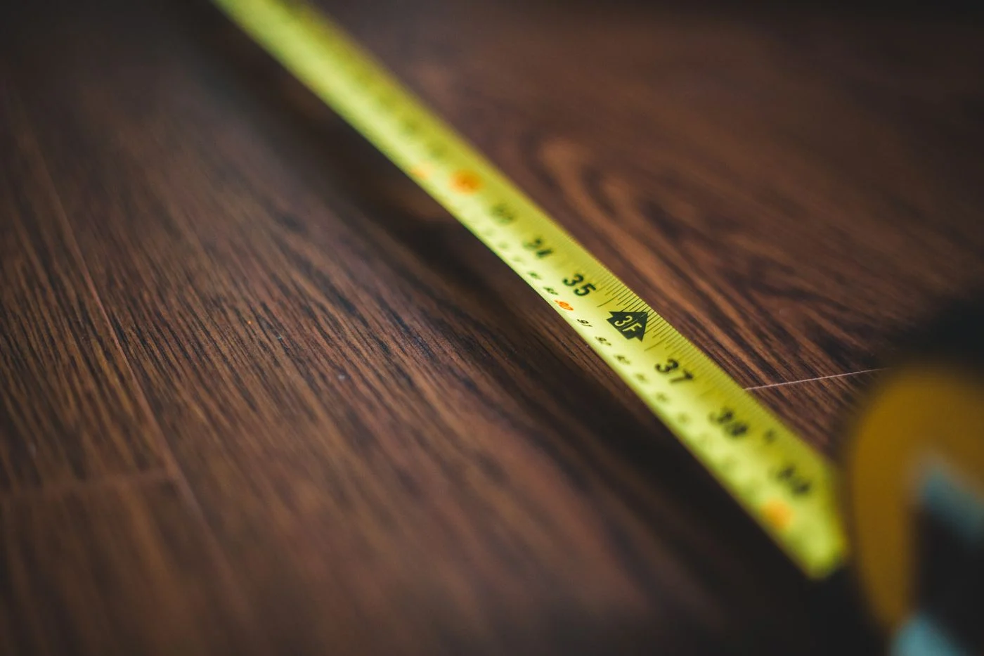 Tape measure extended across a wooden floor