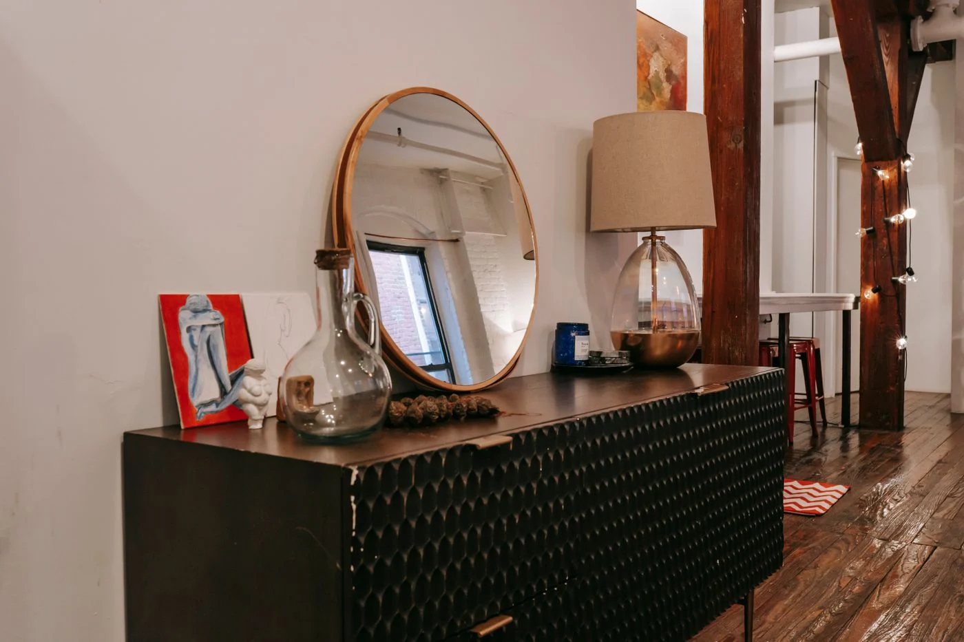 Black chest of drawers and a mirror in a room