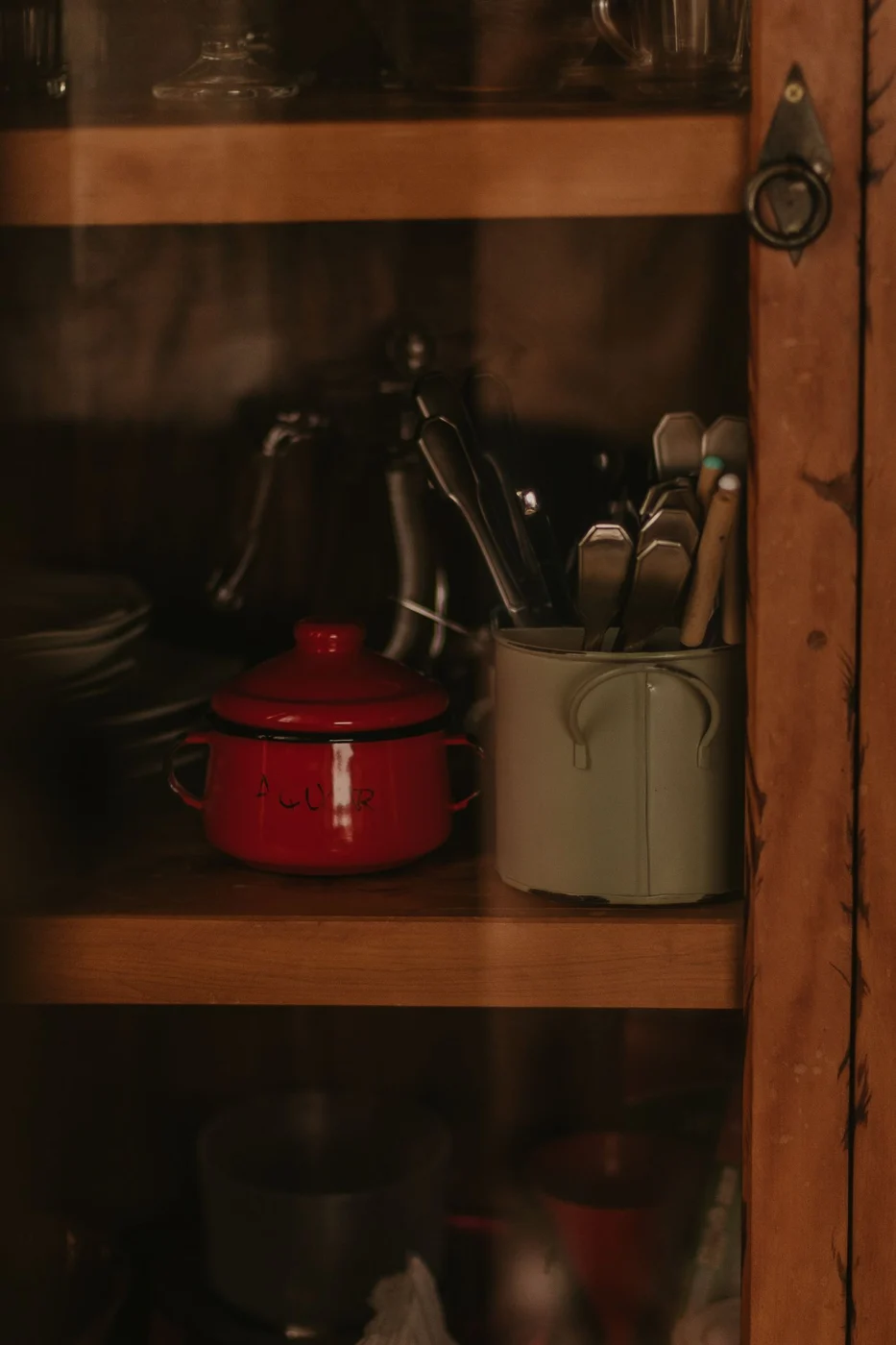 Cookware and dishes stored in a wooden cabinet