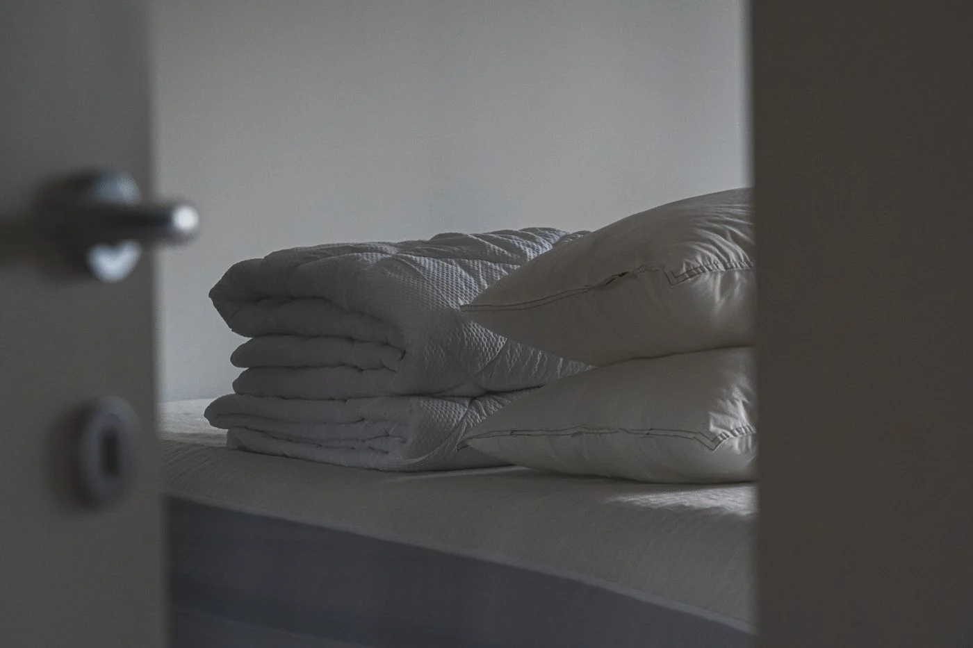 Pillows and folded bedding arranged on a bed