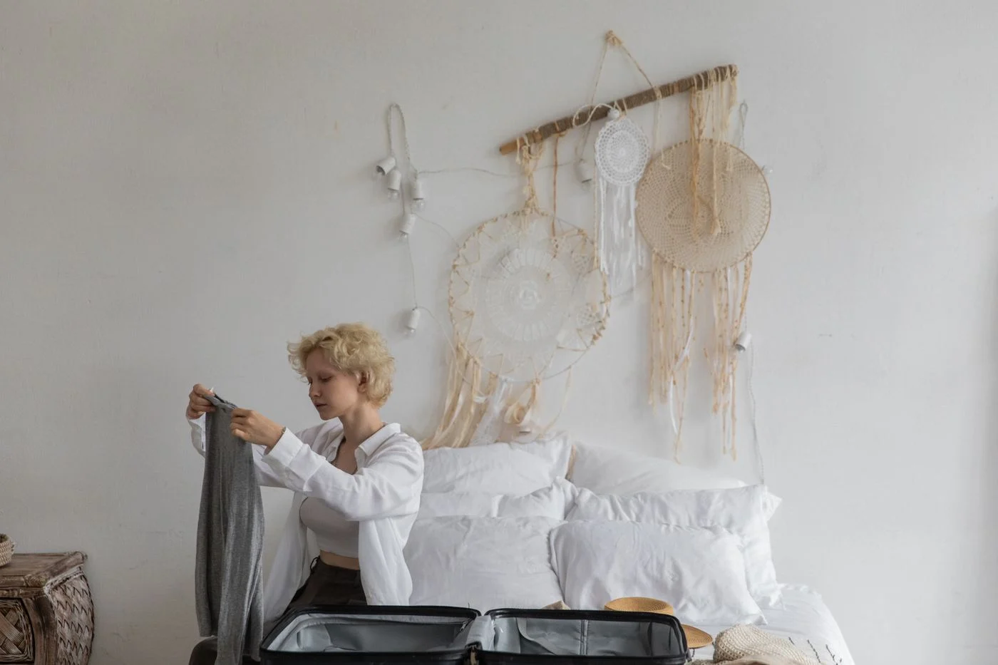 Open suitcase with clothing on a bedroom bed