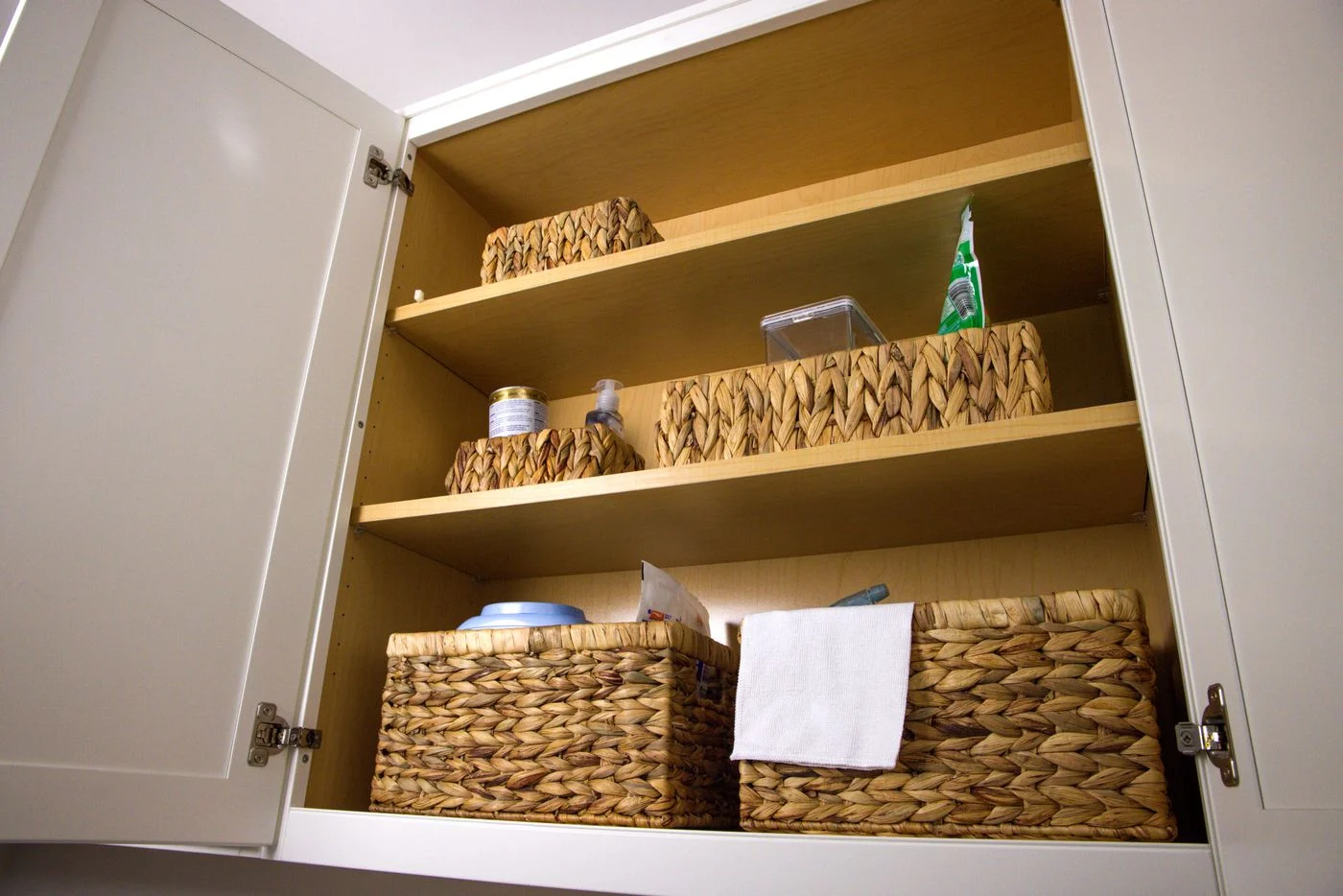 Woven baskets fitted into cupboard shelves