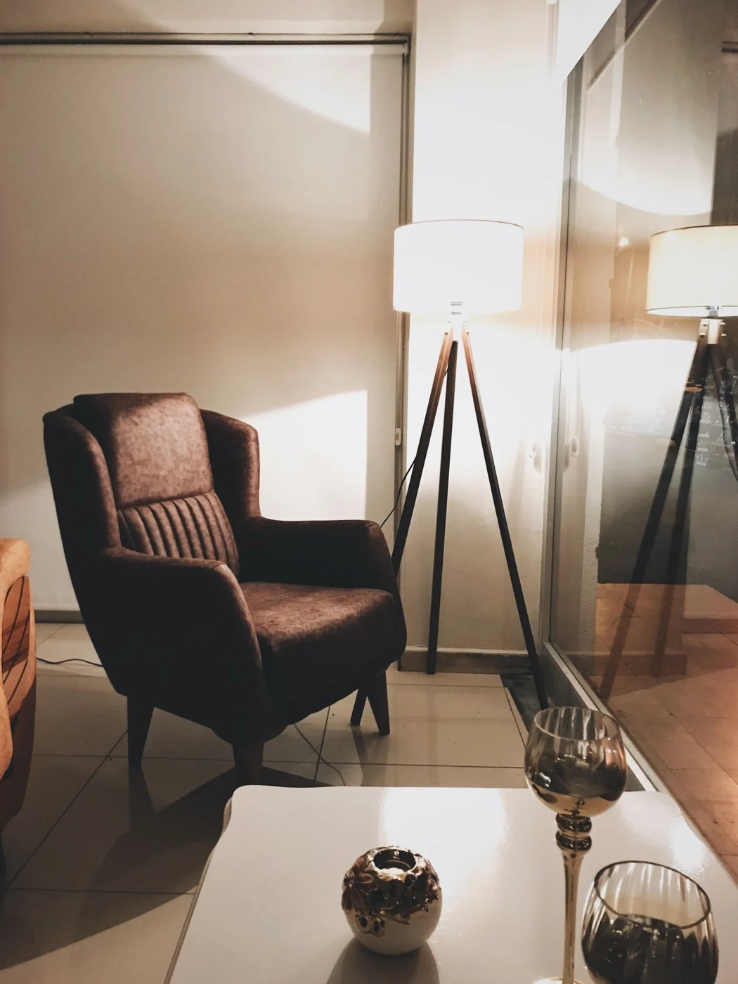 Table lamp and floor lamp beside an armchair