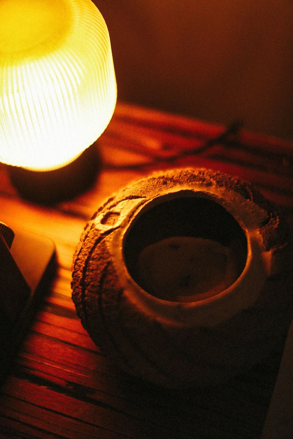 Table lamp casting warm light beside a vase