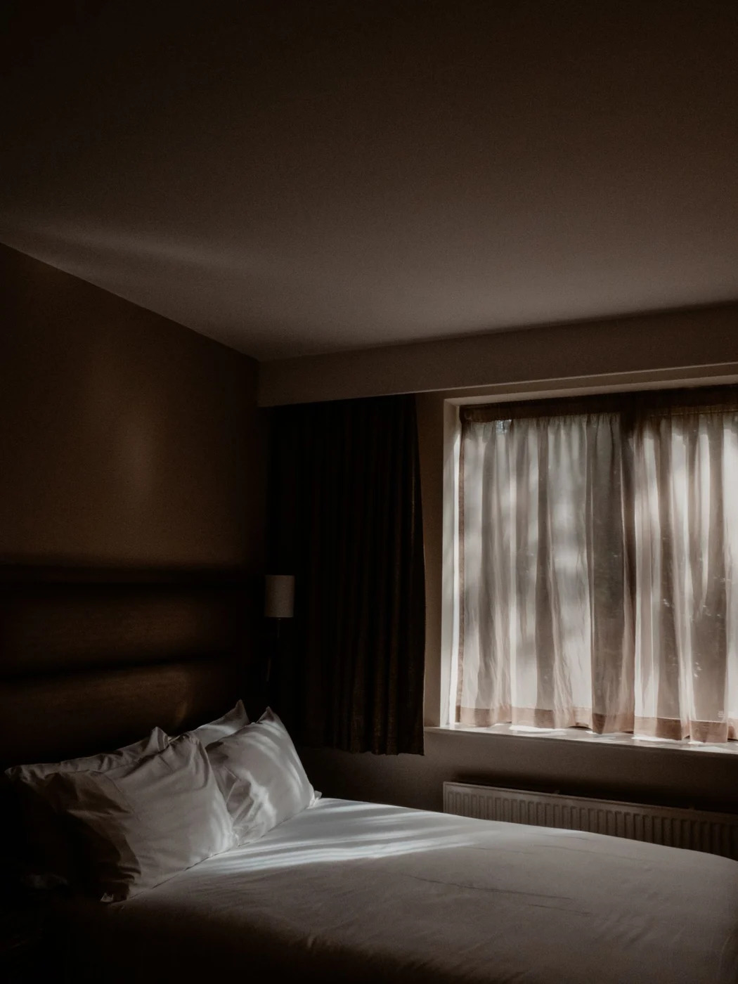 Sheer and darker curtains framing a bedroom window
