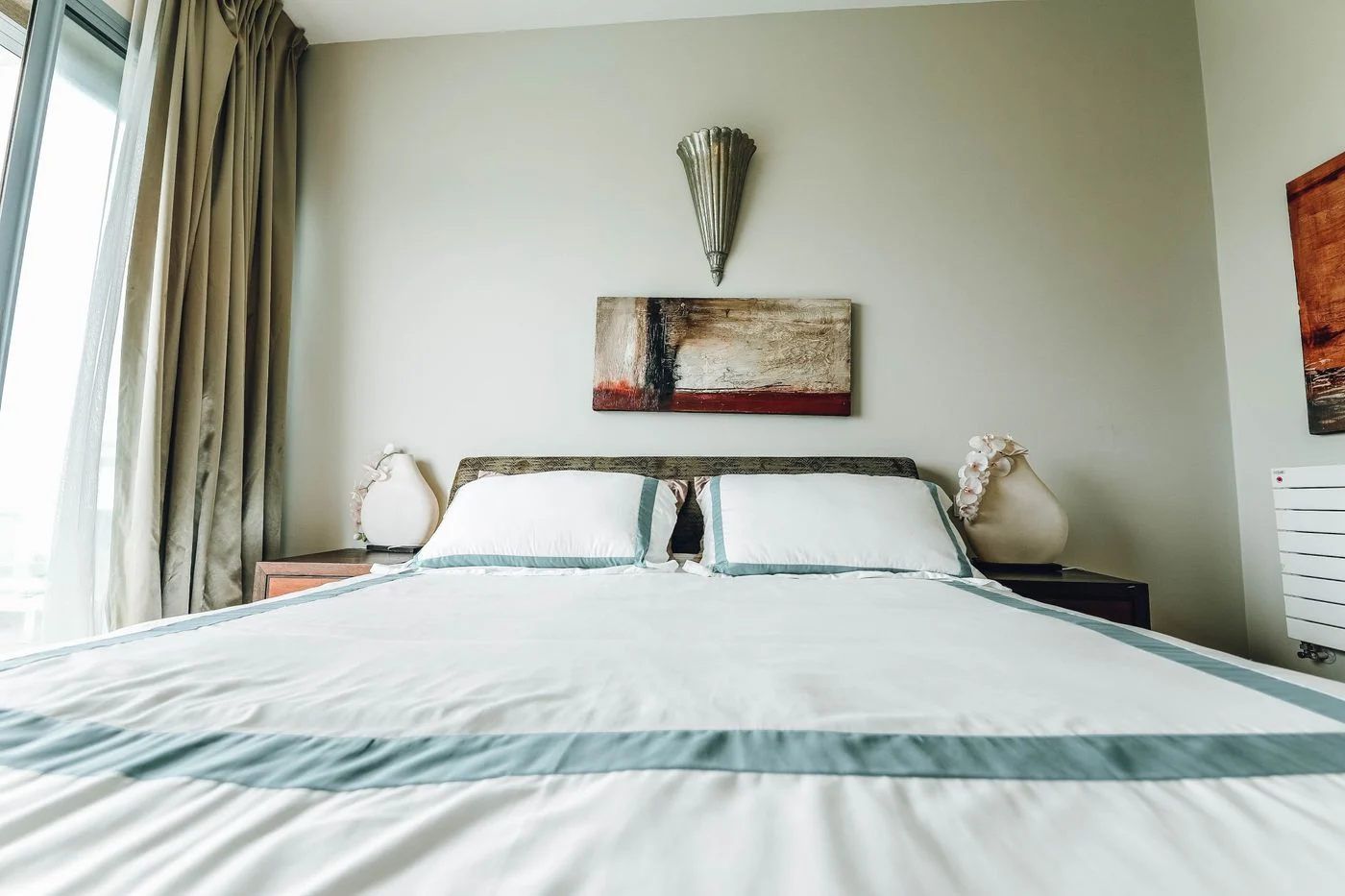 Bedspread over a bed beside a window