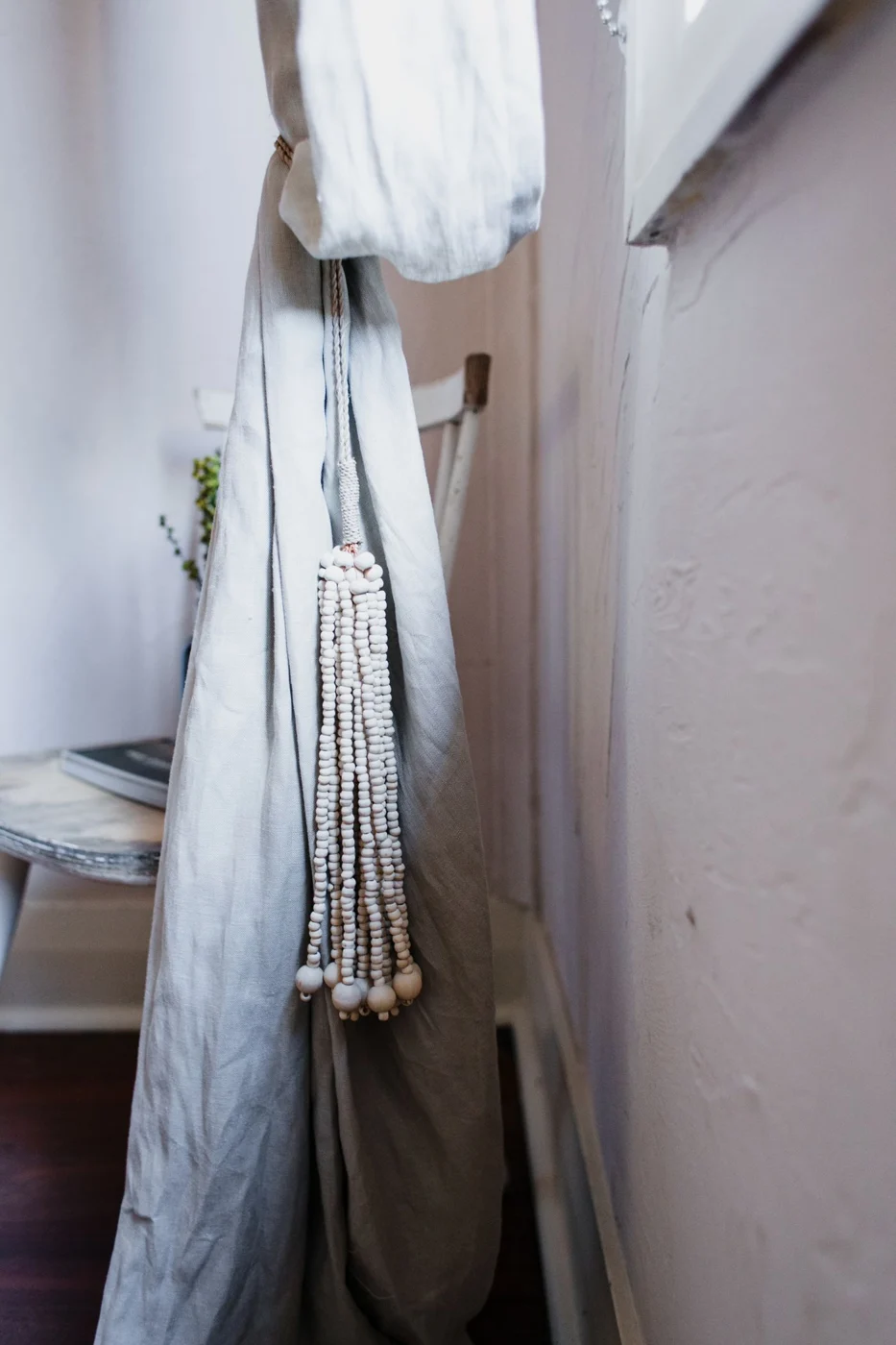 Pale fabric curtain hanging beside a window