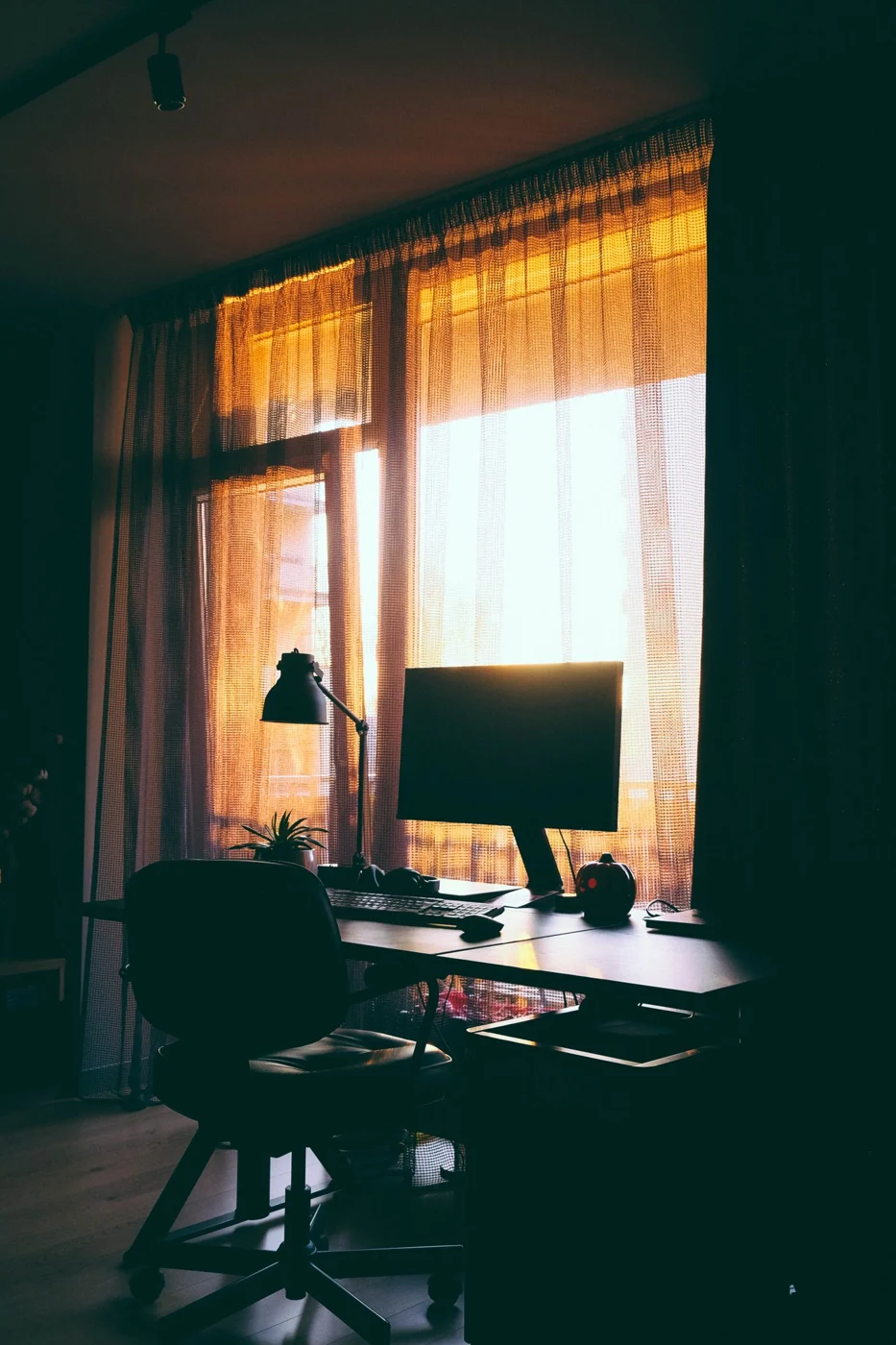 Monitor on a desk beside a window