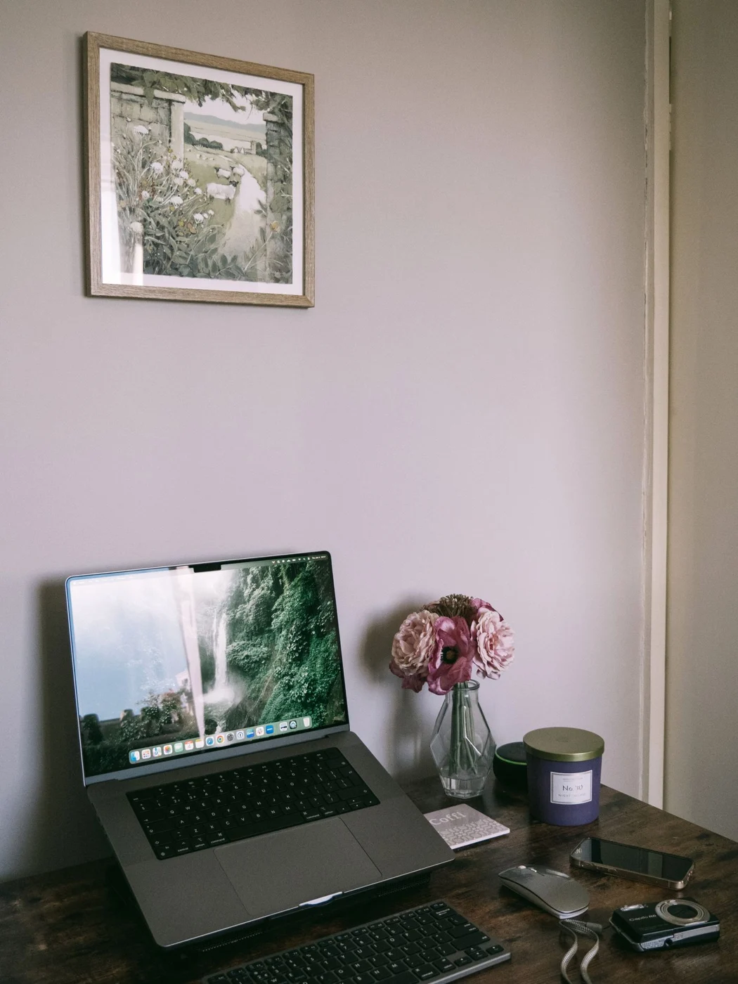 Laptop on a stand with a separate keyboard and mouse on a wooden desk