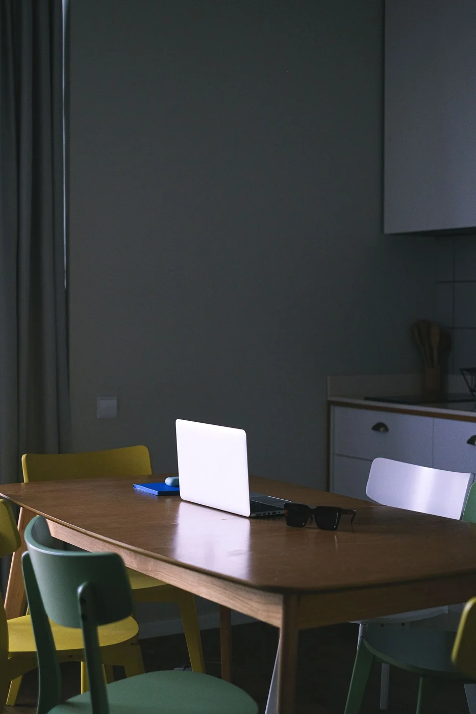 Laptop on a dining table with chairs
