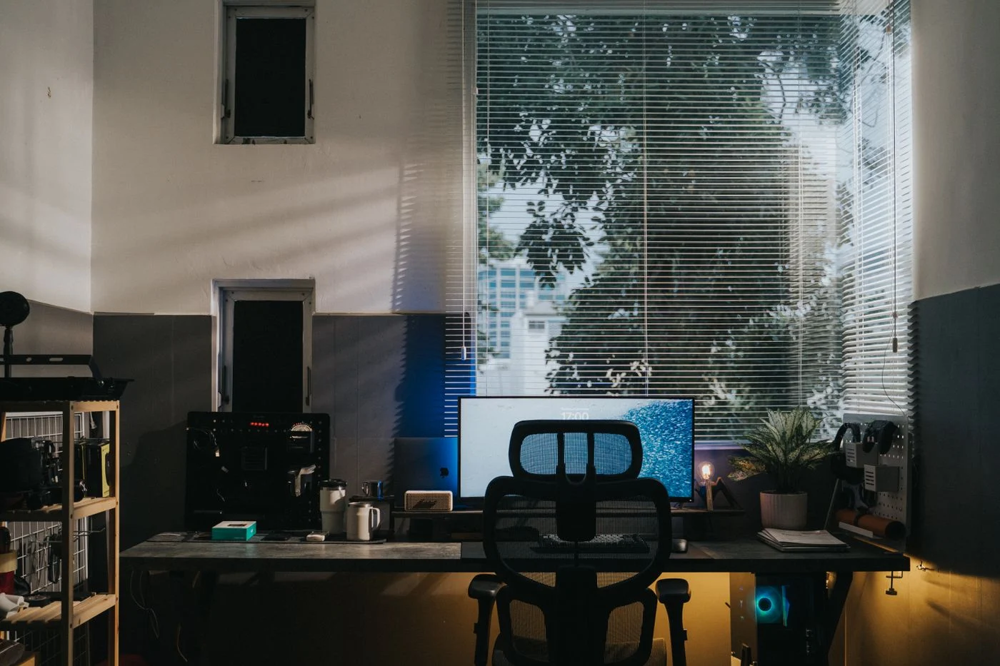 Compact computer desk beneath corner windows