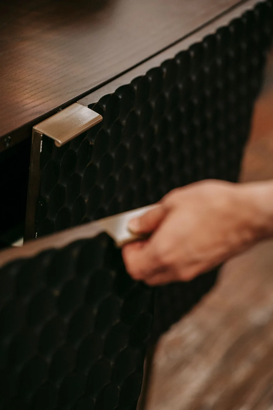 Opening a wooden cabinet door by its handle