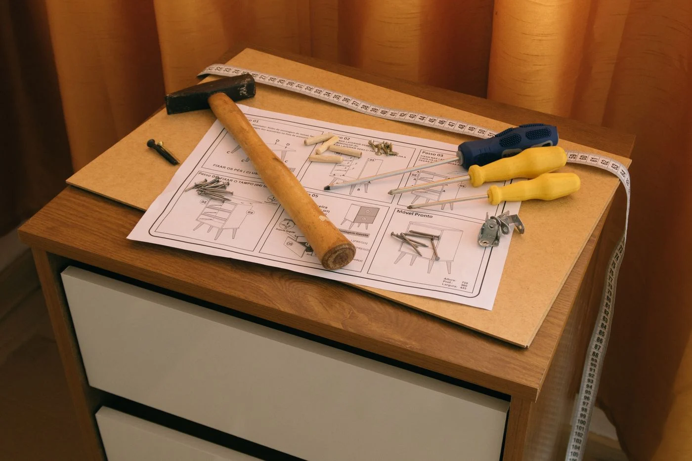 Furniture instruction sheet beside a cabinet and tools